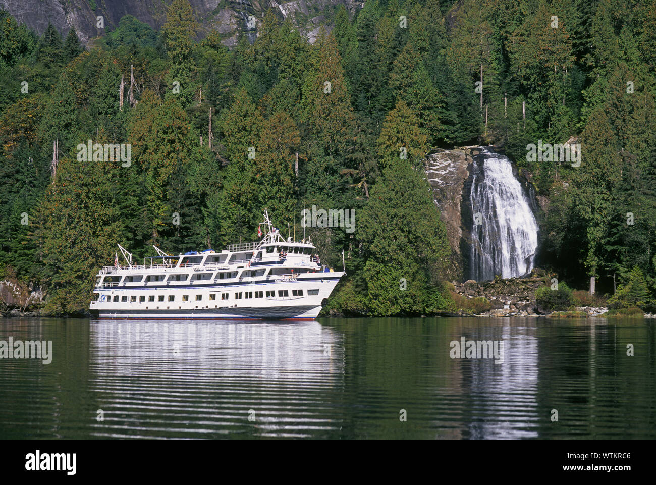 Un petit bateau de croisière donne aux passagers d'examiner de près les chutes Chatterbox dans Princess Louisa Inlet, à l'intérieur de passage dans l'ouest de la Colombie-Britannique, Canada. Banque D'Images