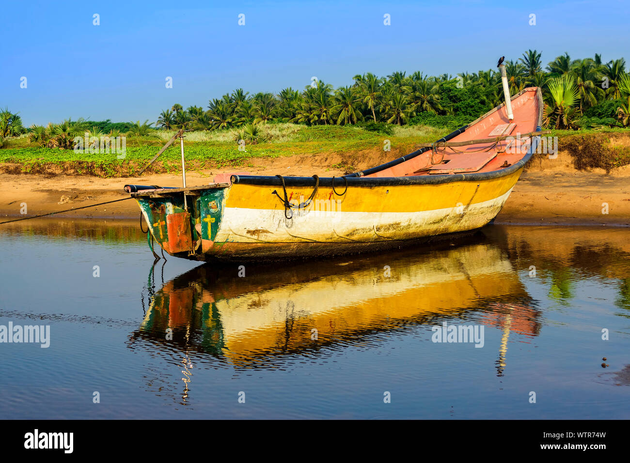 Bateau de pêche colorés locale ancrée dans l'eau peu profonde, copy space Banque D'Images