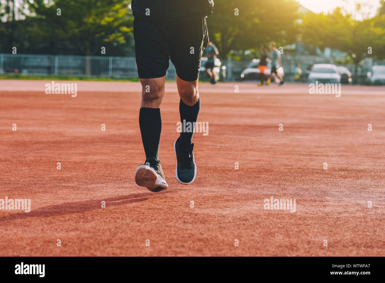 Runner homme jogging ou course en soirée à la lumière du soleil Banque D'Images