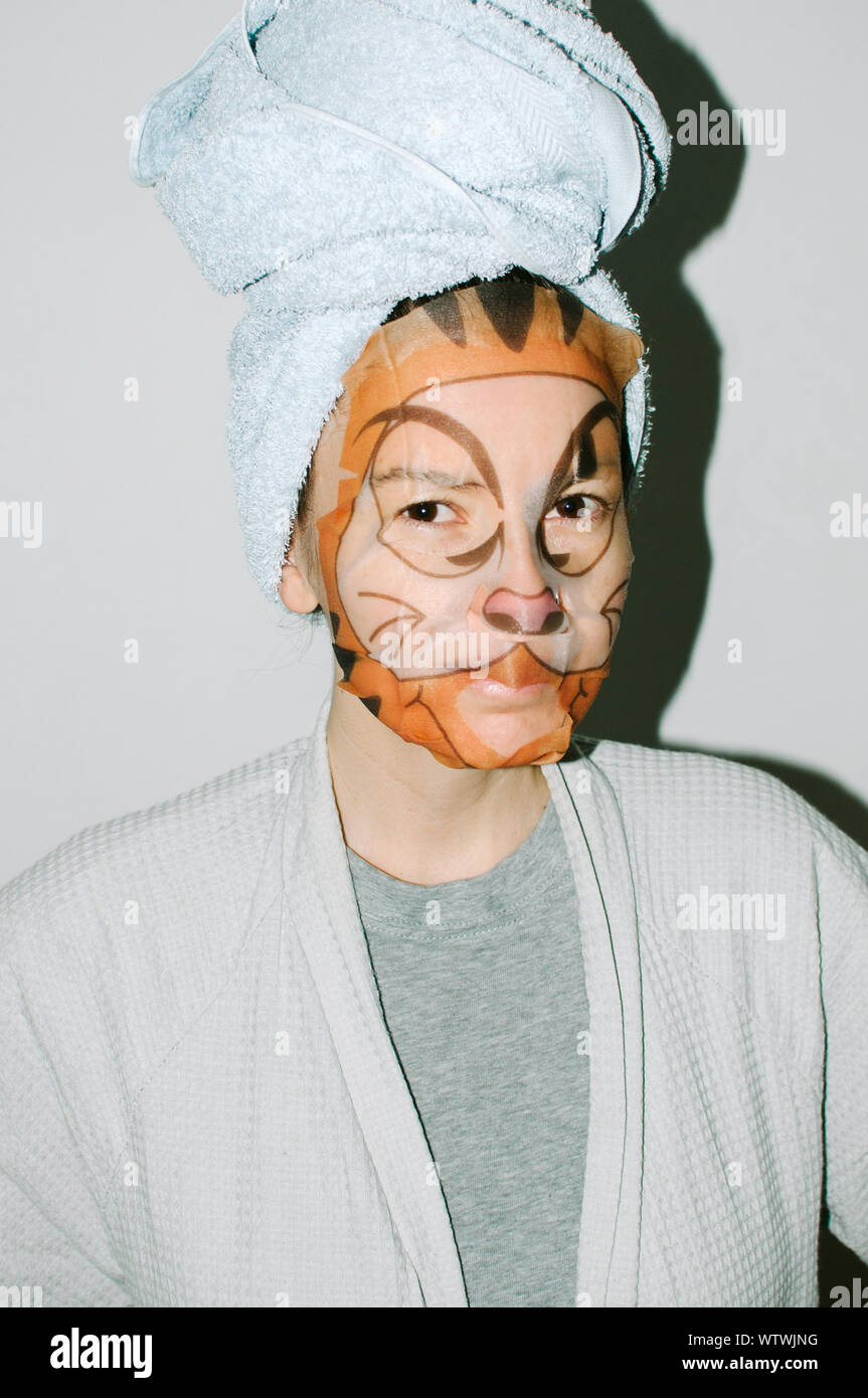 Jeune femme dans un masque de beauté avec impression de tigre Banque D'Images