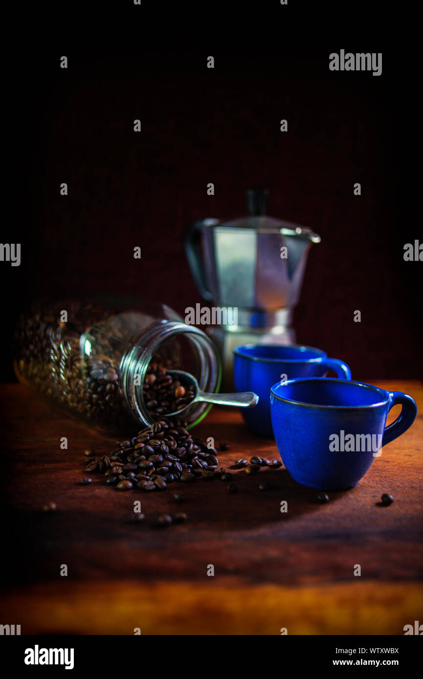 Deux tasses de café traditionnel bleu méditerranéen avec café en grains tumbling à partir d'un bocal. Banque D'Images Deux tasses de café traditionnel bleu méditerranéen avec café en grains tumbling à partir d'un bocal. Banque D'Images