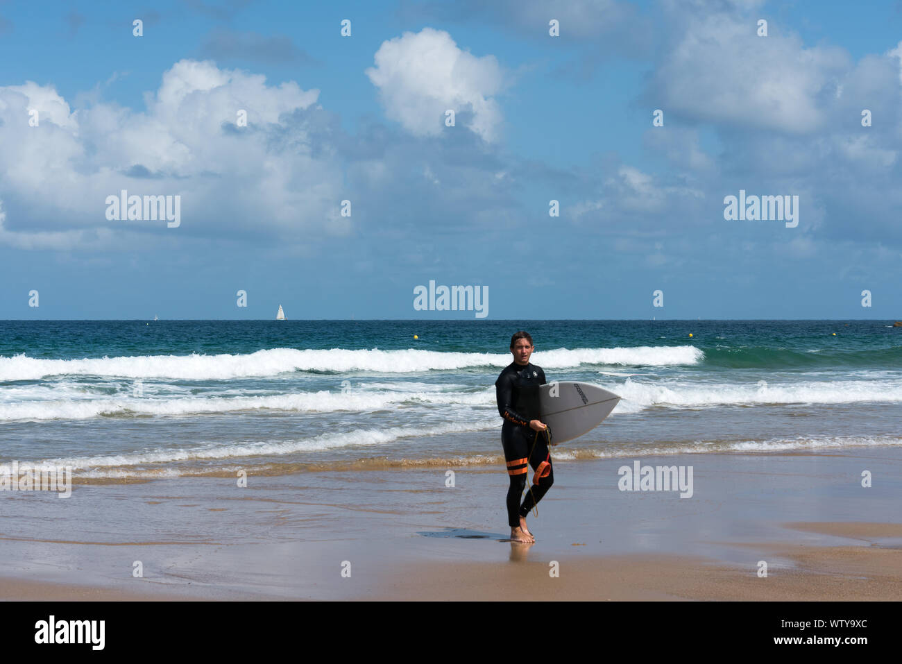 Sables D Or les Pins, Bretagne / France - 20 août 2019 : surfer la marche sur la plage après une session de surf dans les vagues sur la côte de B Banque D'Images