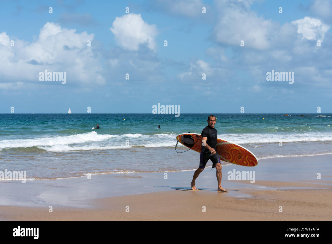 Sables D Or les Pins, Bretagne / France - 20 août 2019 : surfer la marche sur la plage après une session de surf dans les vagues sur les COA Banque D'Images