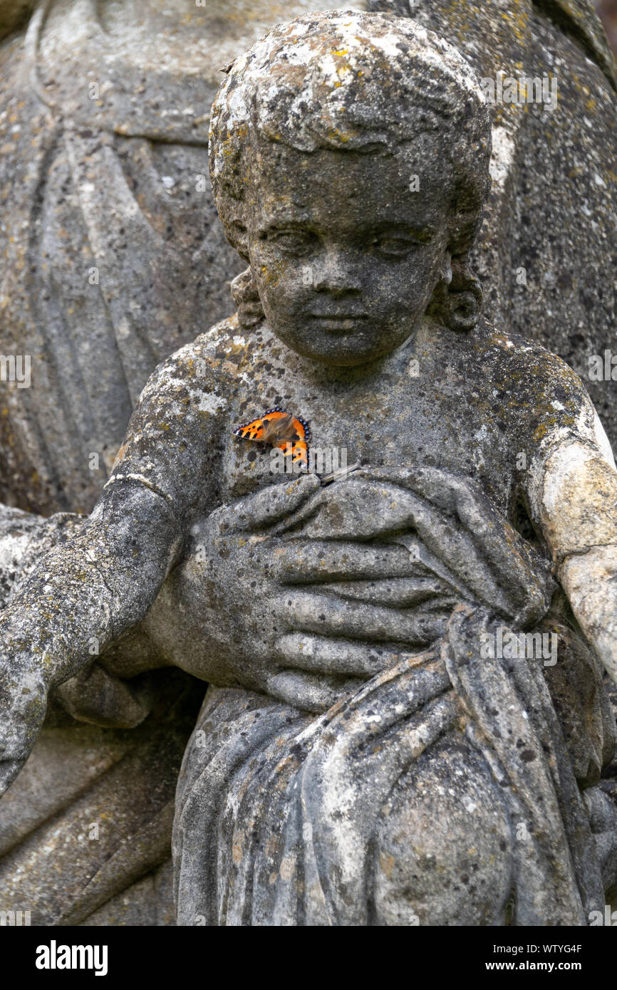 Papillon sur statue de pierre Banque D'Images
