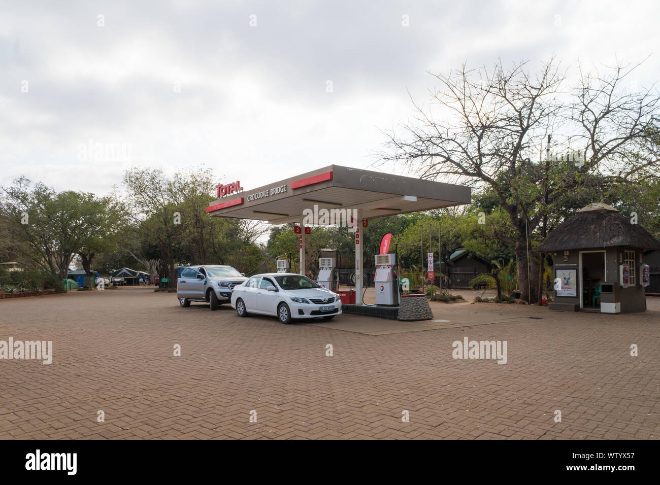 Les voitures ou véhicules au total une essence ou gaz de remplissage jusqu'à la station de pompes à essence à Crocodile Bridge, Kruger National Park, Afrique du Sud Banque D'Images