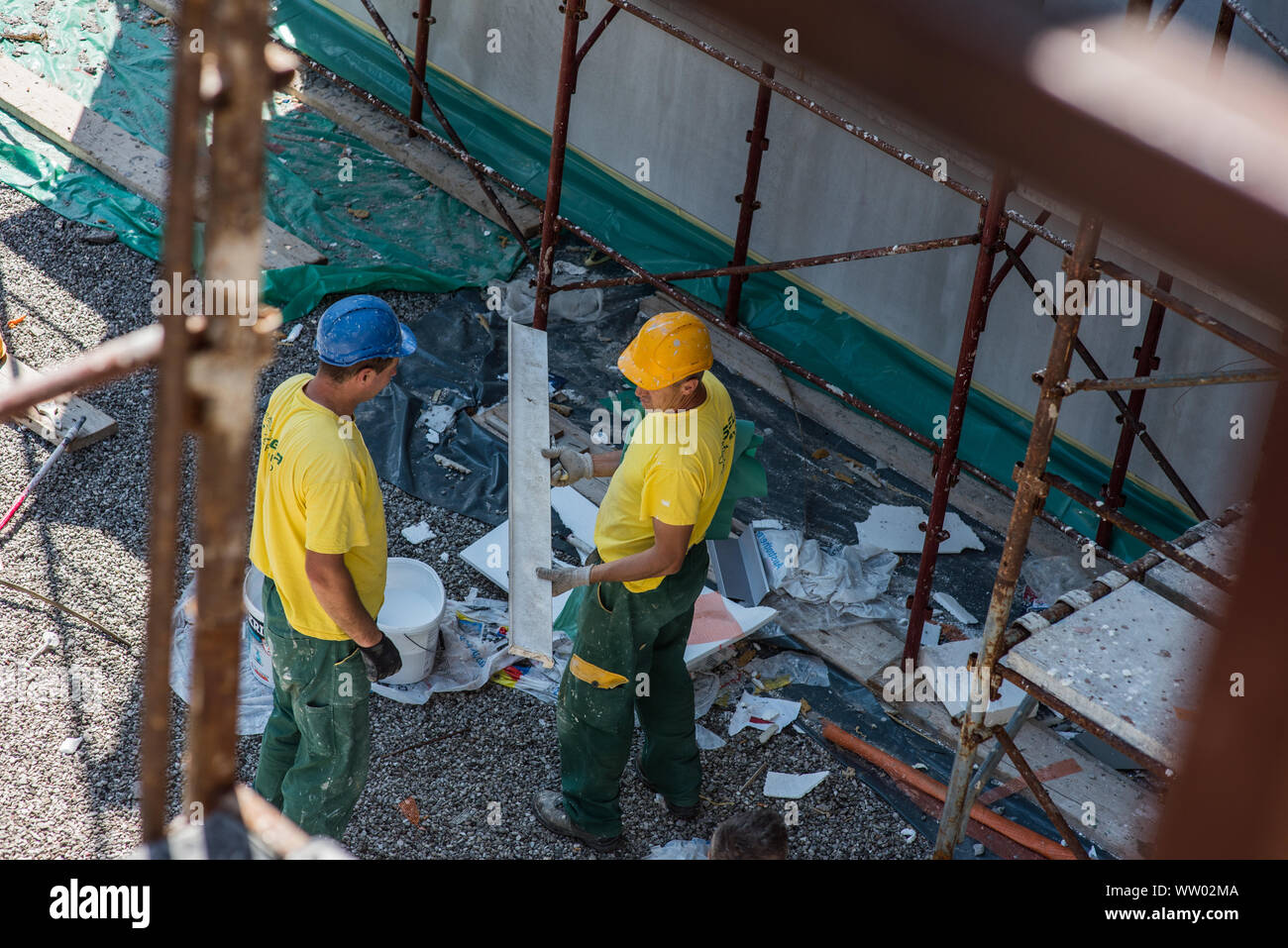 Les hommes sur le site de construction qui travaillent en uniforme. Banque D'Images