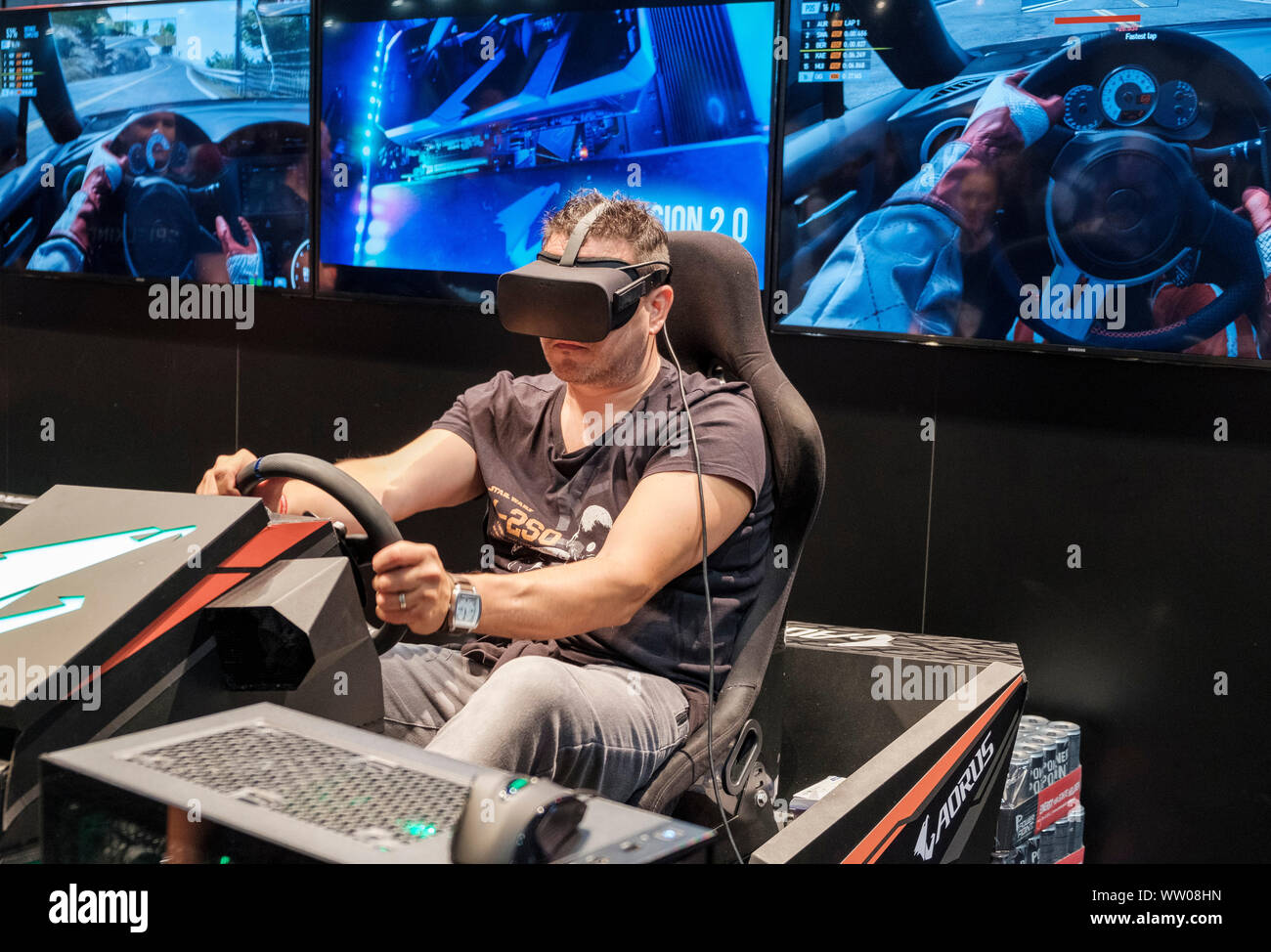 Gamer port casque de réalité virtuelle en simulateur de course de voiture à  la gamescom , le plus grand salon du monde pour l'ordinateur et les jeux  vidéos à Cologne, Allemagne le