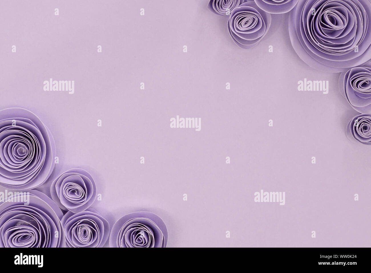 Créations en papier violet pastel fleur rose avec des fleurs d'arrière-plan de mise à plat sur le coin supérieur droit et inférieur gauche et copie vide au milieu de l'espace Banque D'Images