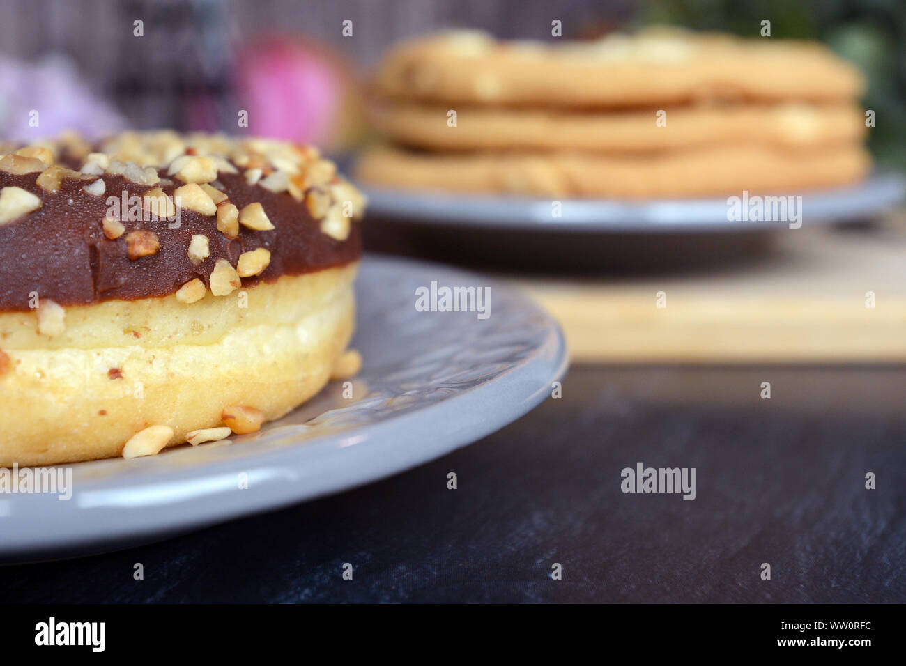 Close up de l'écrou sur sprinkles donut avec vitrage avec chocolat pâtisserie flou en arrière-plan Banque D'Images