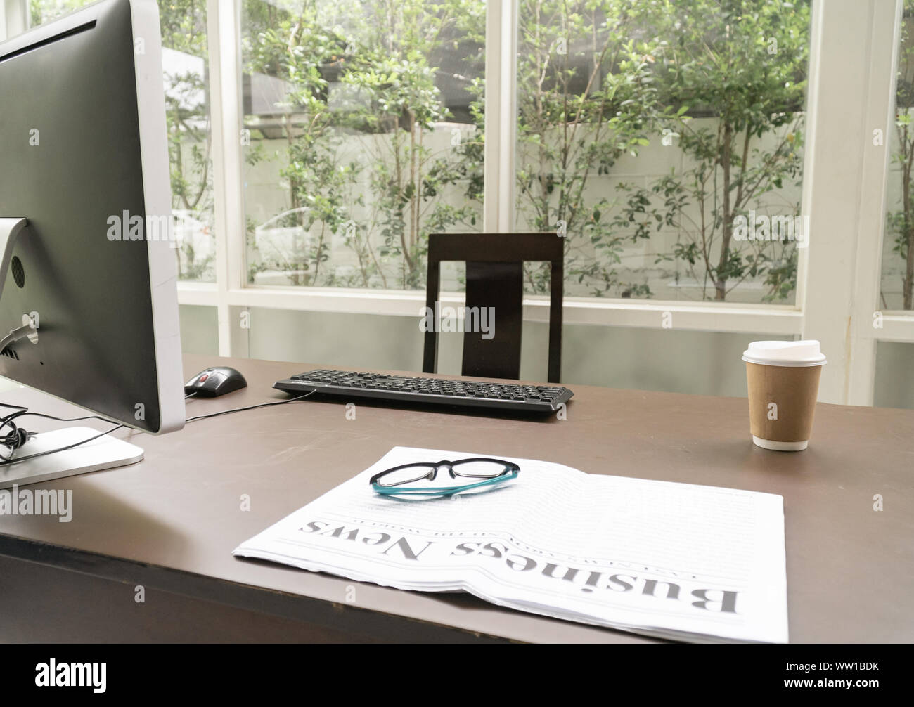 Journal d'entreprise avec une tasse de café sur le bureau de l'ordinateur au bureau à domicile. Banque D'Images