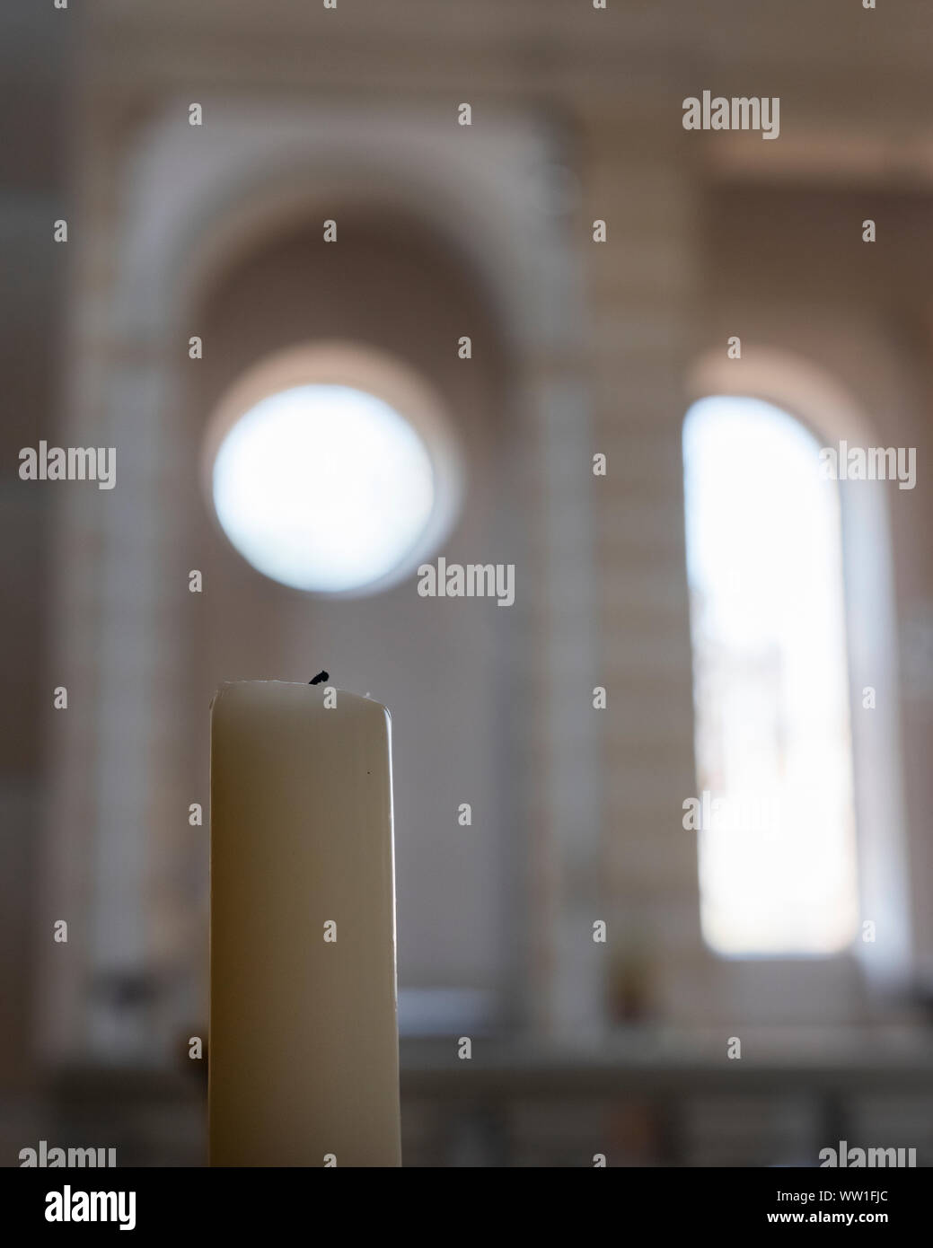 Bougie blanche église avec fenêtres romanes dans l'arrière-plan Banque D'Images