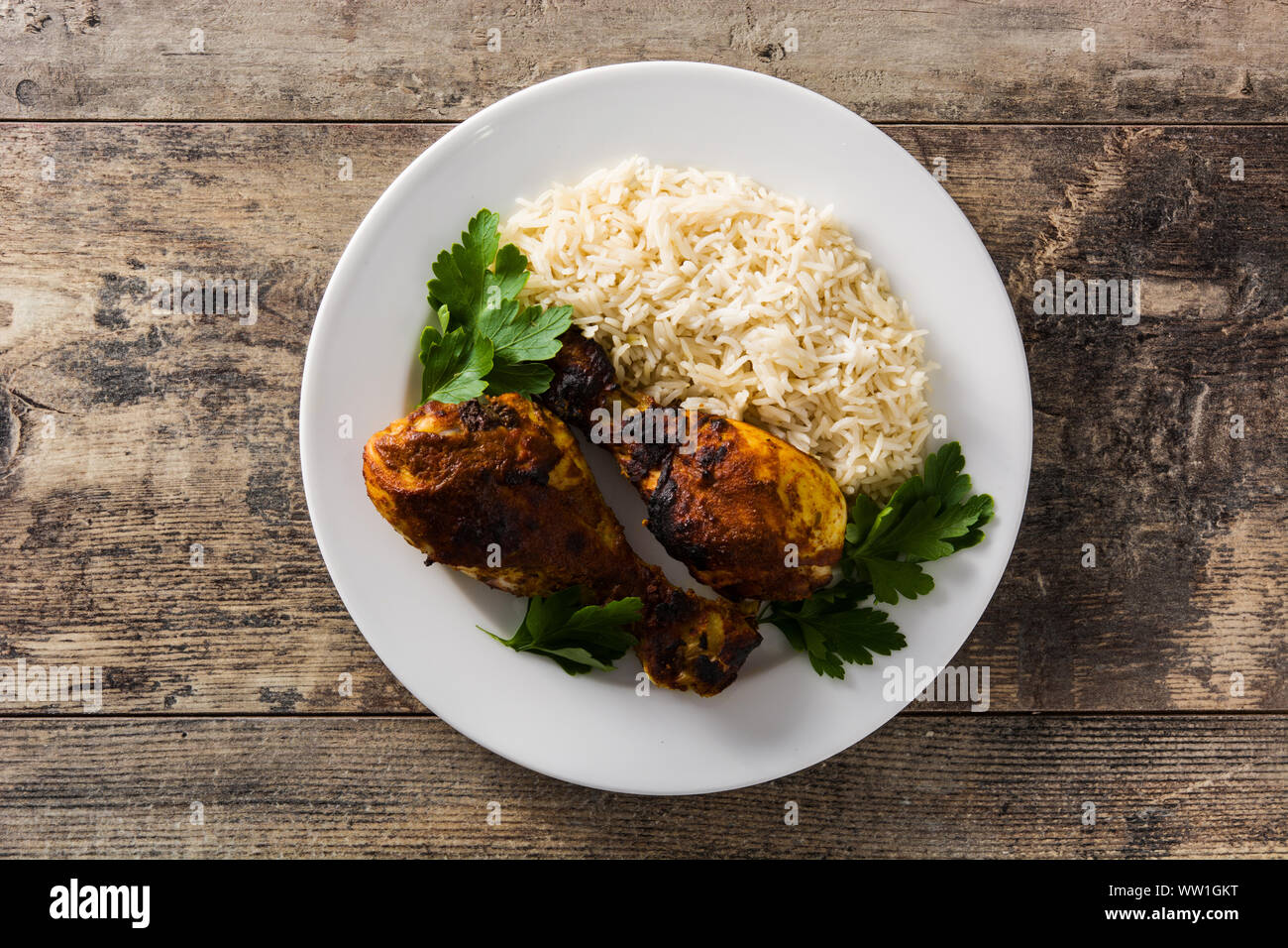 Poulet tandoori grillés avec du riz basmati en plaque sur les tables en bois. Vue d'en haut. Banque D'Images
