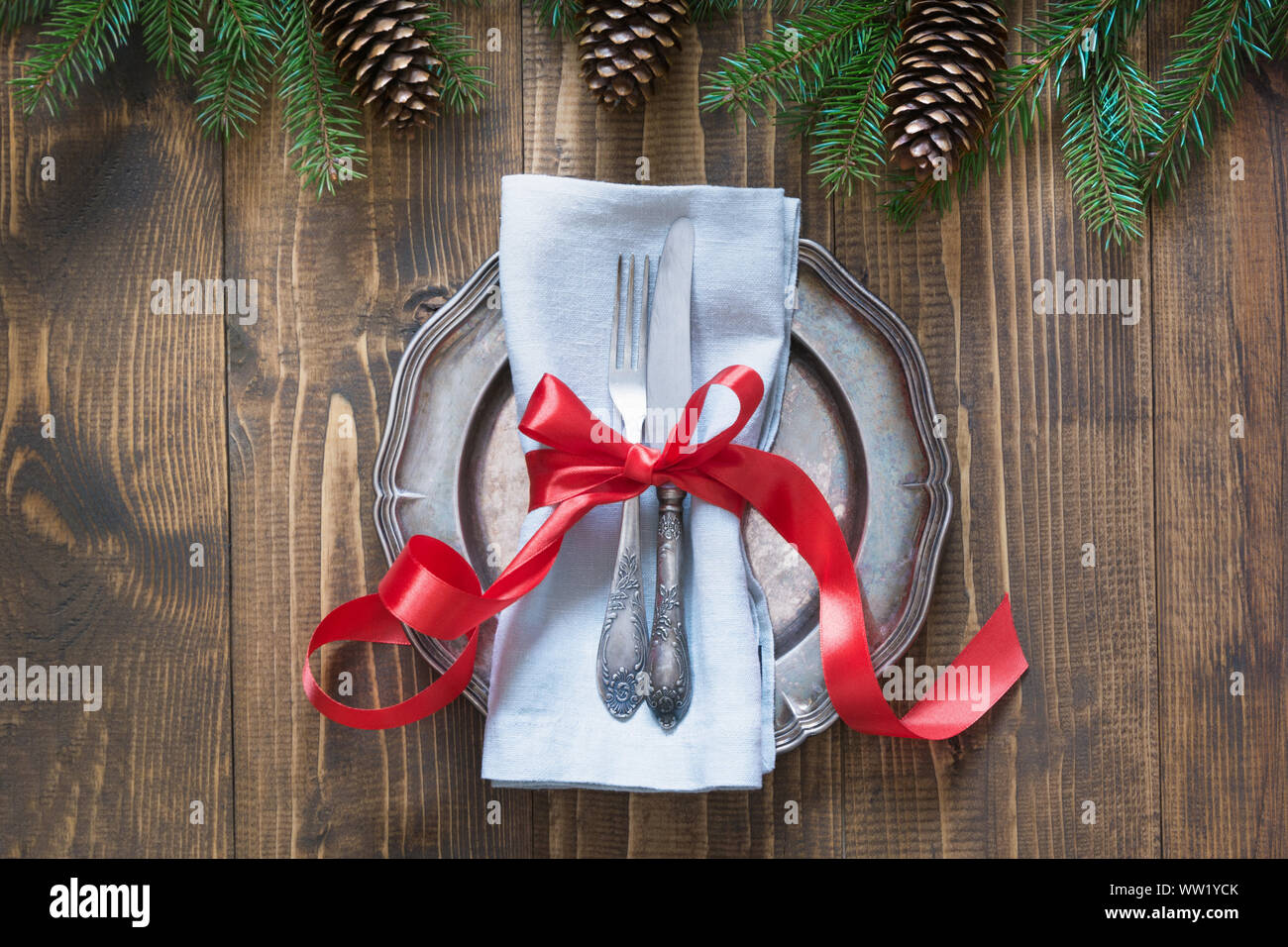 Réglage de la table de Noël avec Candy Cane et ruban rouge comme décor, la vaisselle vintage, l'argenterie et les décorations sur planche de bois. Vue d'en haut. Banque D'Images
