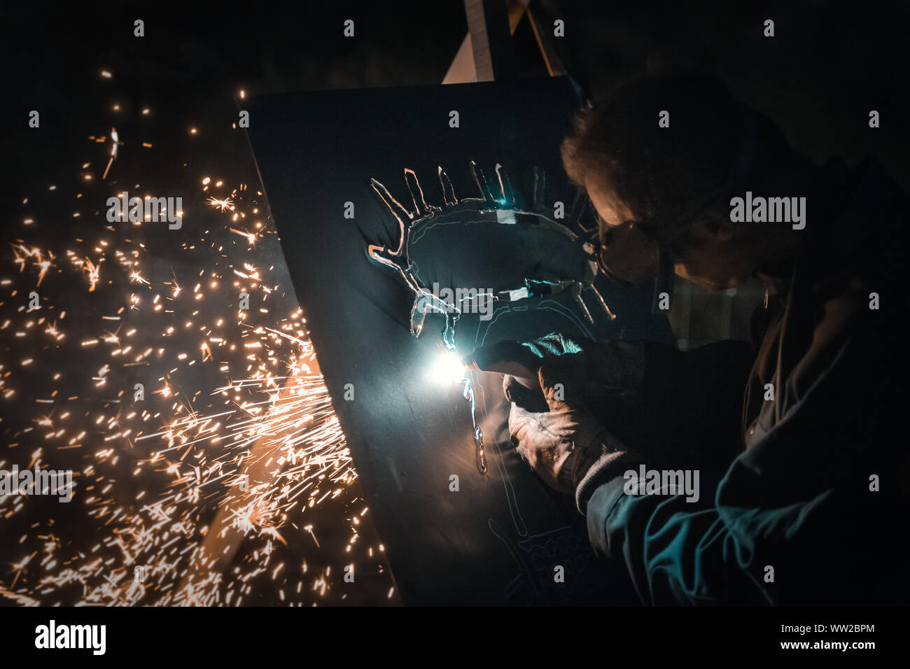 Les travailleurs du métal utilisent la main-d'œuvre manuelle, le soudeur qualifié, l'artiste soudeur, le soudeur soudez l'acier dans l'usine, les fumées de soudage et les particules, le welde Banque D'Images