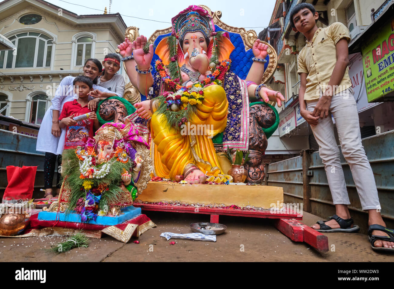 Au cours de la procession du Festival Ganesh à Mumbai, Inde, adorateurs de dieu éléphant Ganesh (Ganpati) monter sur un véhicule avec statues de Ganesh Banque D'Images