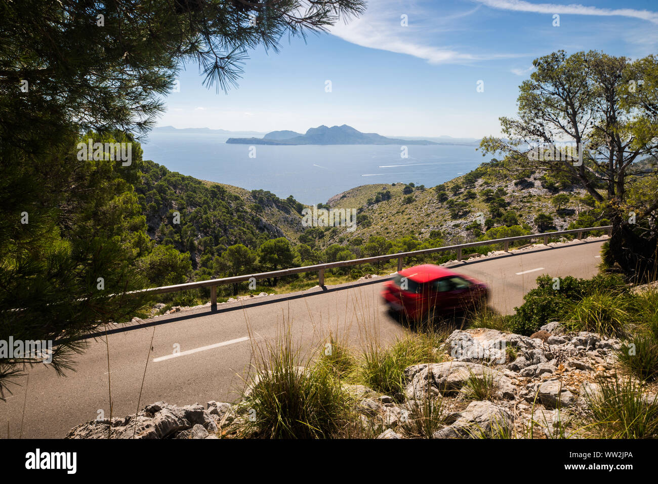 Route étroite à Cap Formentor avec motion rouge voiture floue, Majorque, Iles Baléares Banque D'Images