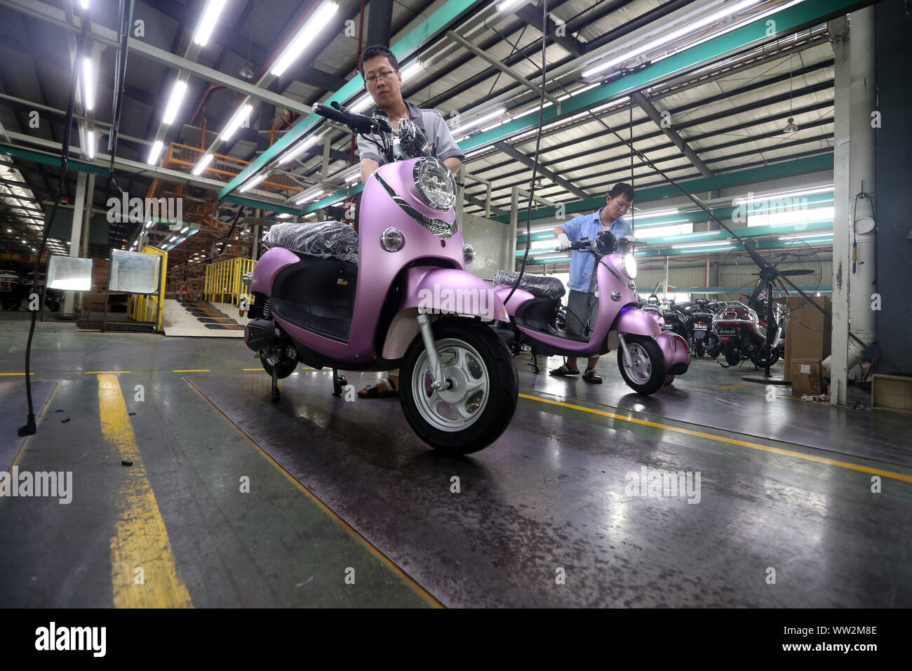 Les travailleurs d'usine chinois nouvellement test vélos électriques fabriqués à l'usine de BGB Sichuan Electric Vehicle Co., Ltd. à Emei, ville du sud-ouest de la Chine. Banque D'Images
