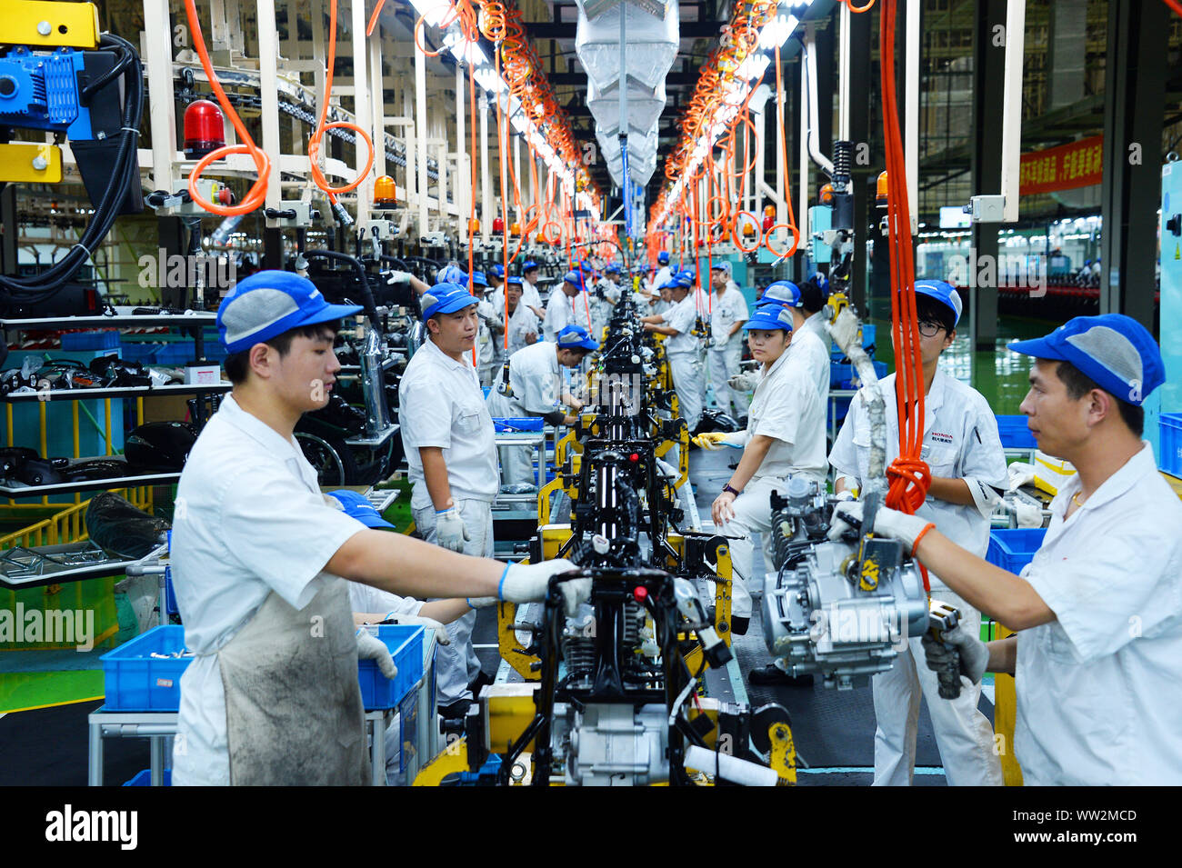 Les travailleurs d'usine chinois assembler des motos sur la ligne d'assemblage à l'usine de motocyclettes Honda Sundiro Co., Ltd. à Taicang City, East China's Jia Banque D'Images
