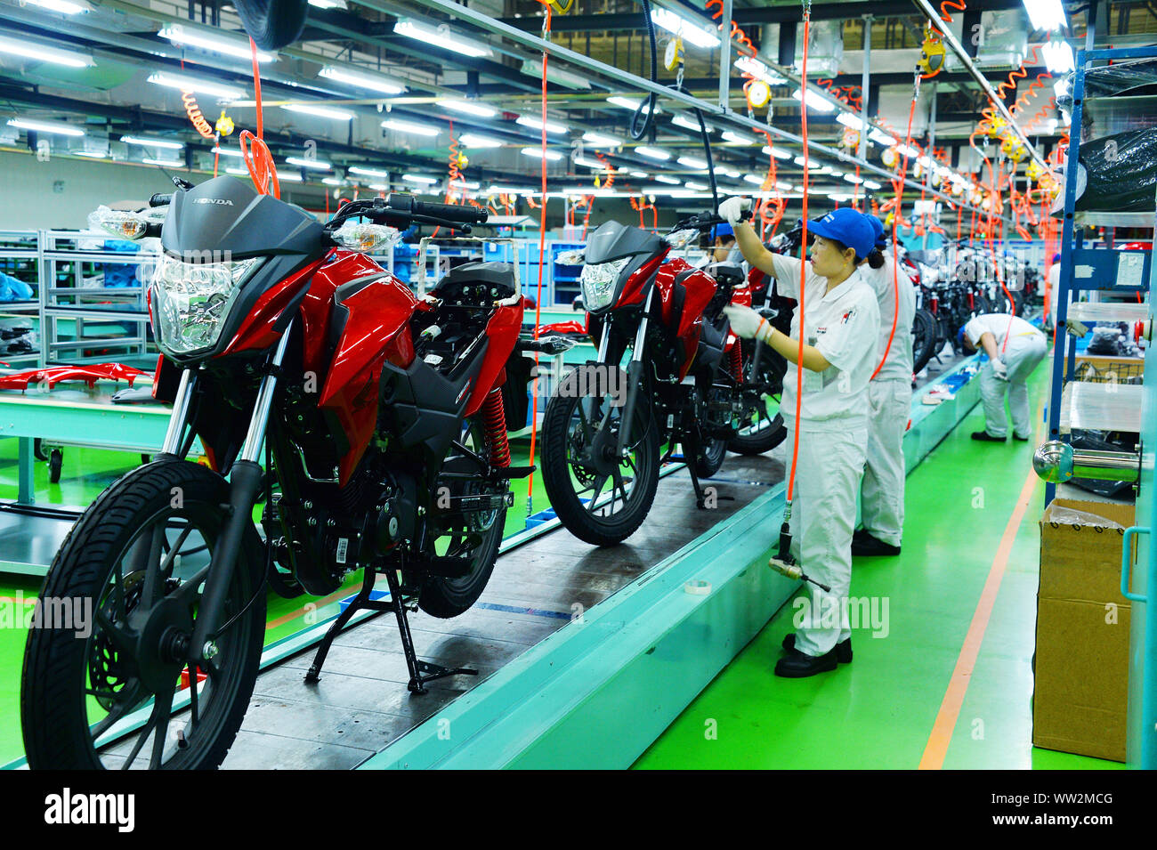 Les travailleurs d'usine chinois assembler des motos sur la ligne d'assemblage à l'usine de motocyclettes Honda Sundiro Co., Ltd. à Taicang City, East China's Jia Banque D'Images