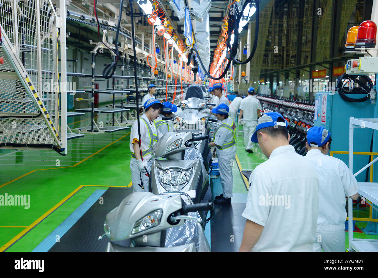 Les travailleurs d'usine chinois assembler des motos sur la ligne d'assemblage à l'usine de motocyclettes Honda Sundiro Co., Ltd. à Taicang City, East China's Jia Banque D'Images