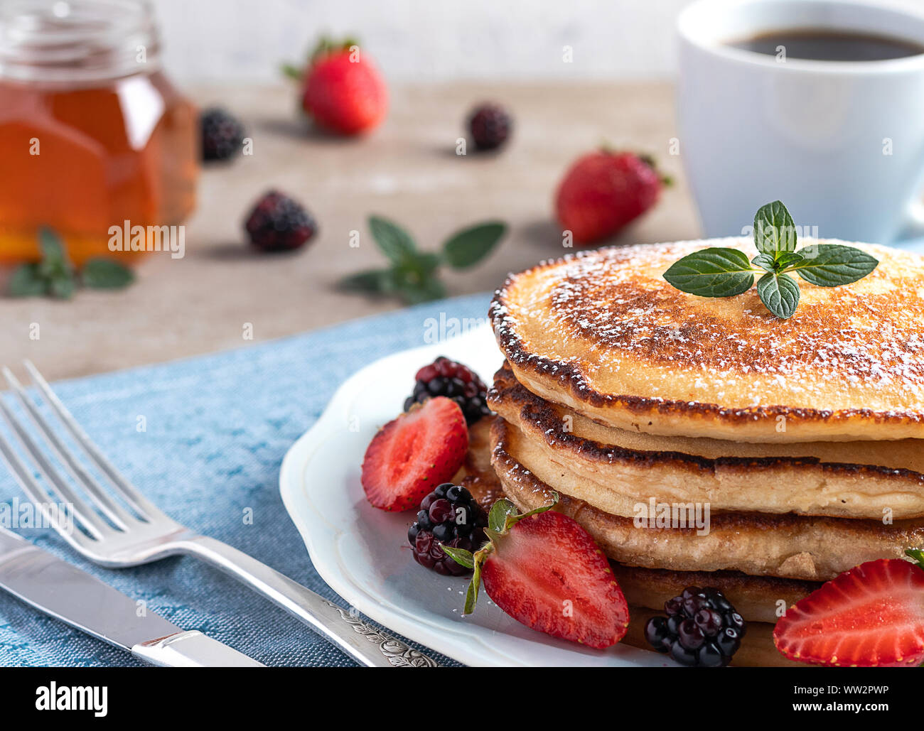 Petit déjeuner avec crêpes, les fraises, le café et le miel Banque D'Images