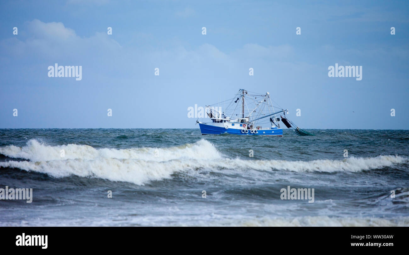 Bateau de crevettes filet traînant dans une mer Banque D'Images