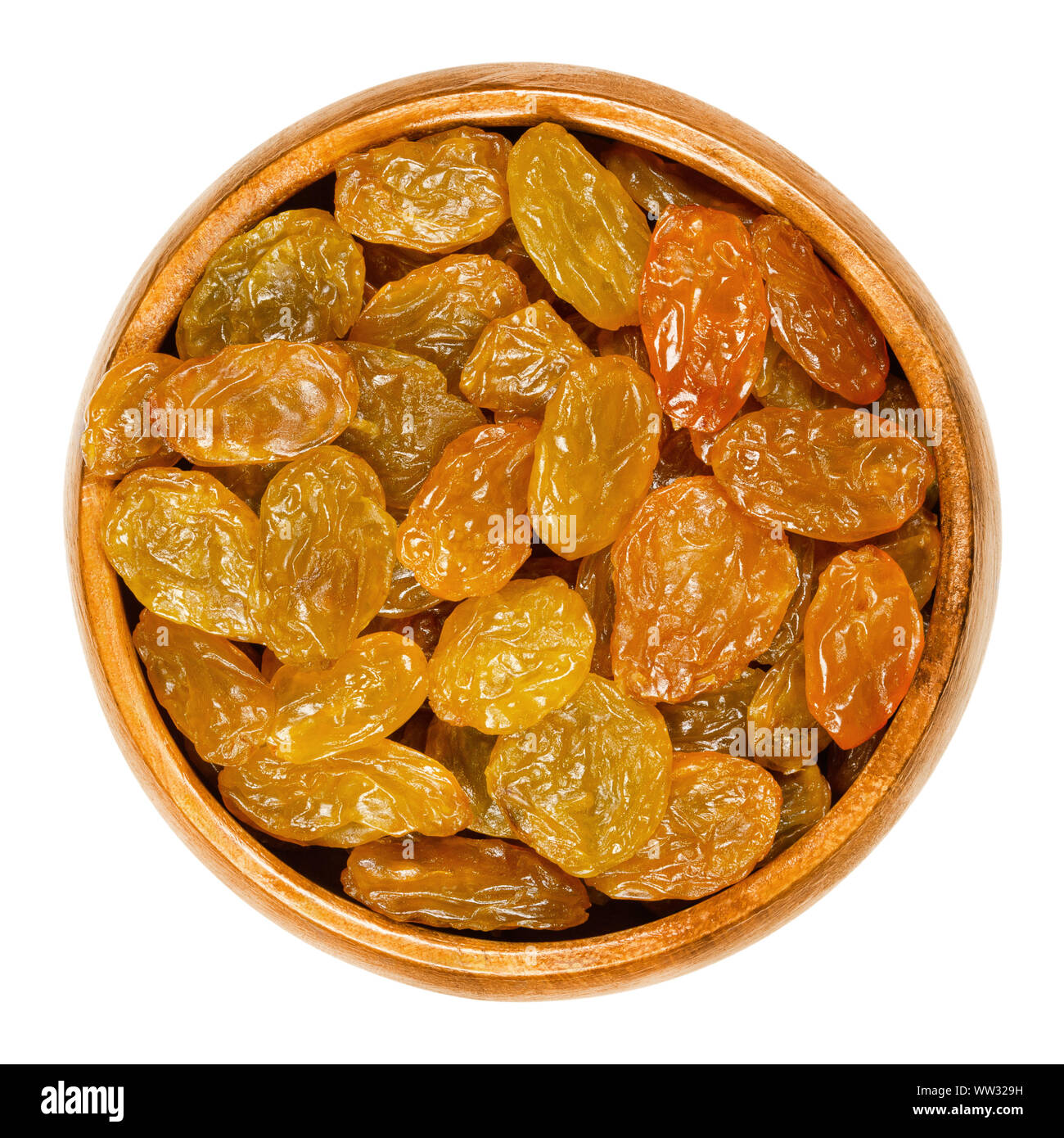 Sultanines, raisins dorés, dans bol en bois. Grand, de couleur or, les raisins secs sont consommés crus ou utilisé en cuisine et pâtisserie. Close up, d'en haut. Banque D'Images
