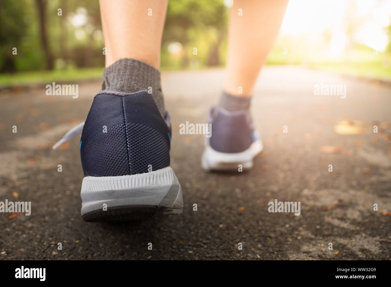 Jogging femme dans Central Park en portant des chaussures de sport de l'exercice dans la soirée coucher du soleil. Banque D'Images