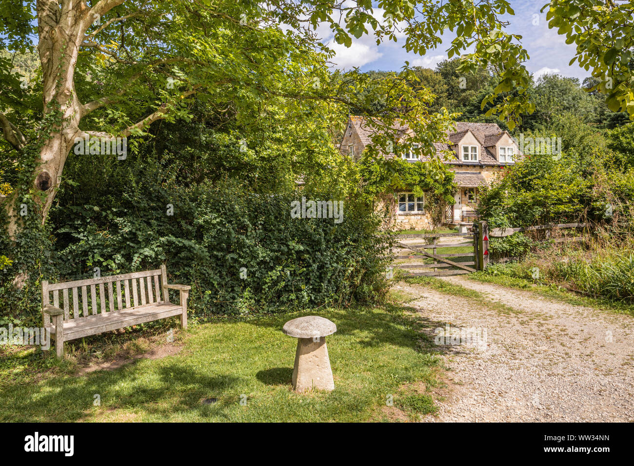 Un cottage en pierre à côté de la voie dans le village des Cotswolds de Buckland, Gloucestershire UK Banque D'Images