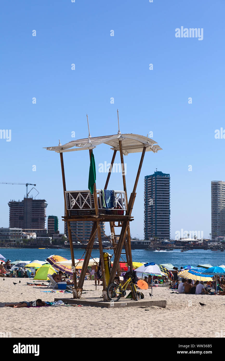 IQUIQUE, CHILI - 23 janvier 2015 : maître-nageur sur la plage de Cavancha guet avec des bâtiments modernes à l'arrière sur une péninsule, le 23 janvier, 2015 Banque D'Images