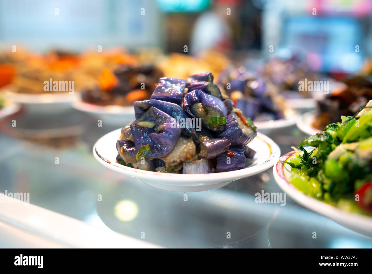 Incorporez l'aubergine japonais tiré sur la petite plaque sur la table en verre à côté d'une variété de plats dans un restaurant taiwanais à Taiwan Banque D'Images