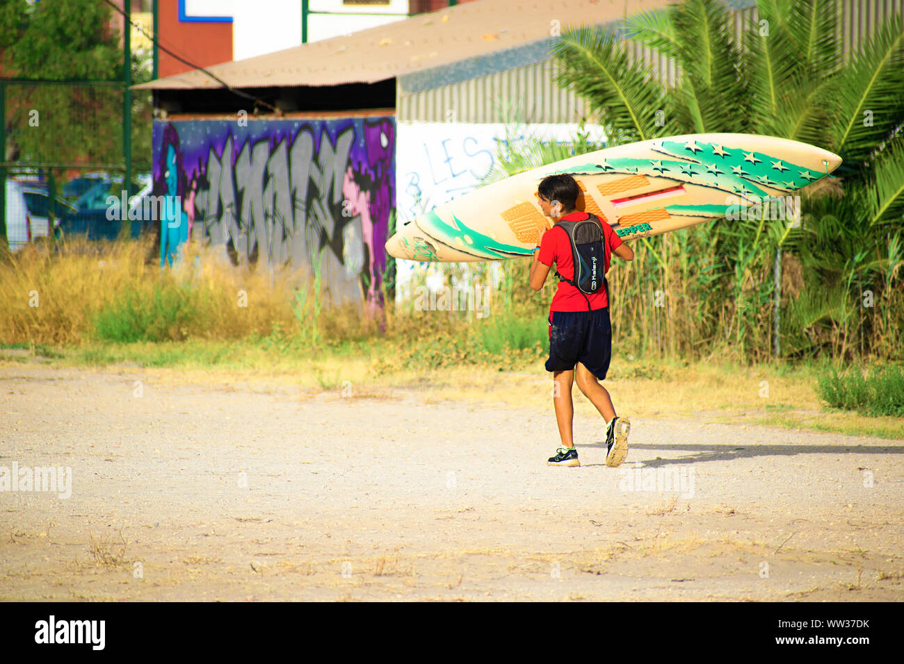 Alicante, Espagne, le 22 août 2019 : un jeune sportif avec son longboard à la plage Banque D'Images