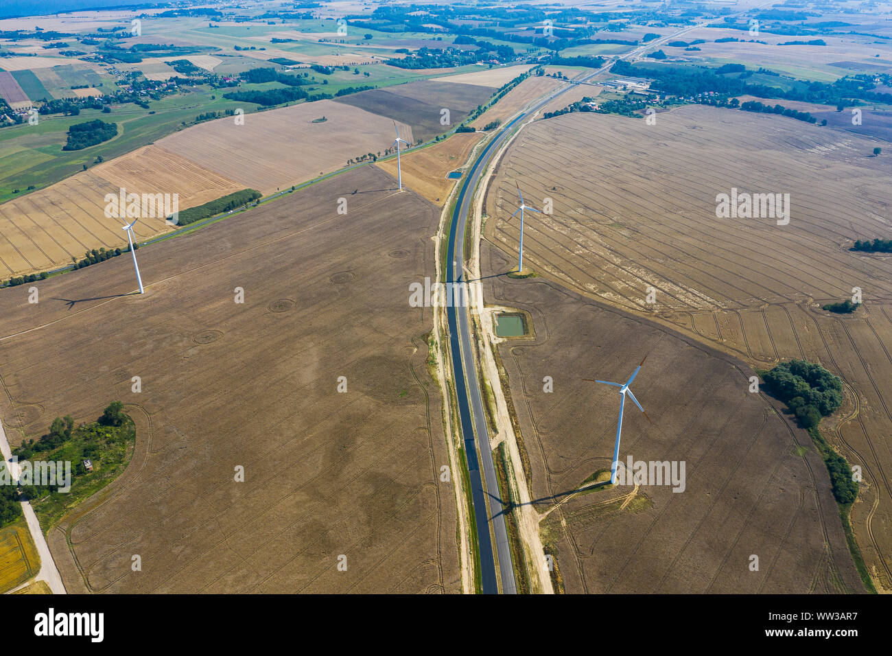 Éolienne sur le champ arable. route à côté de terres agricoles Banque D'Images