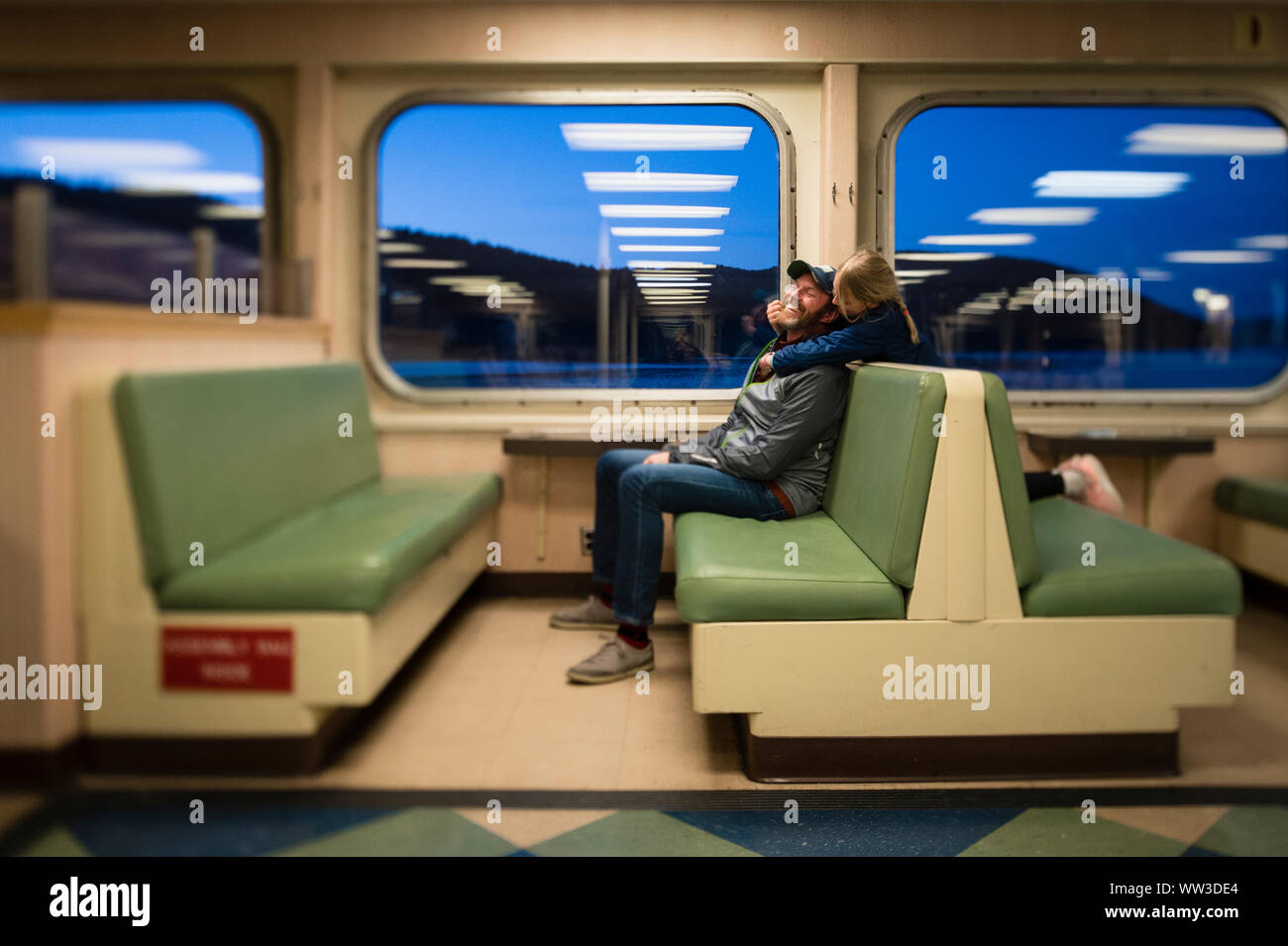 Homme et enfant serrant dans l'intérieur du bateau dans l'État de Washington Banque D'Images