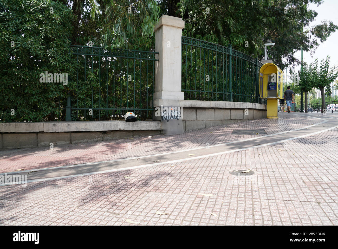 Casque de police et le bouclier sur la chaussée et leaning against fence prêt à l'emploi dans le besoin se fait sentir. Banque D'Images