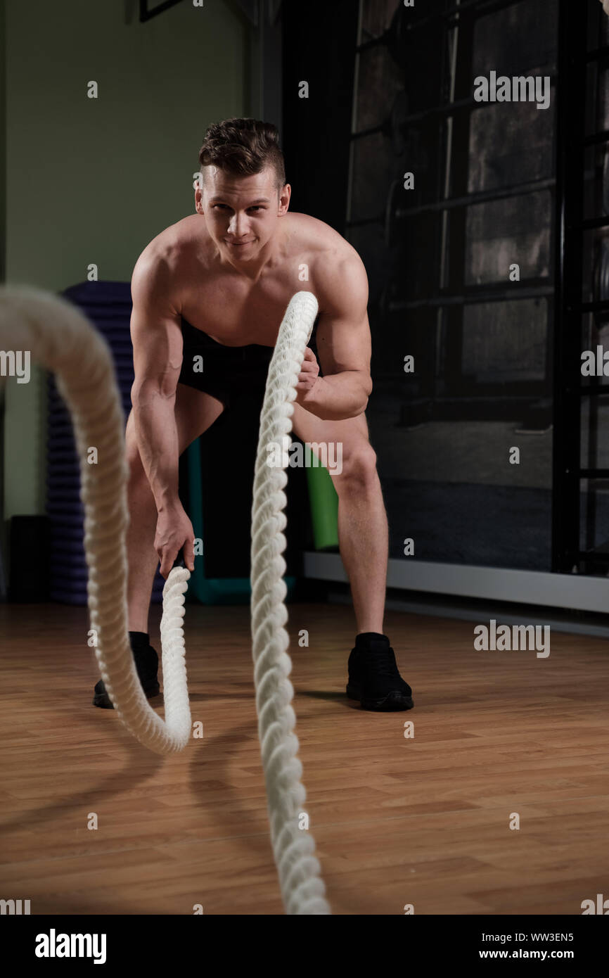 L'homme musclé avec corde bataille faire de l'exercice dans la salle de sport de la formation fonctionnelle Banque D'Images