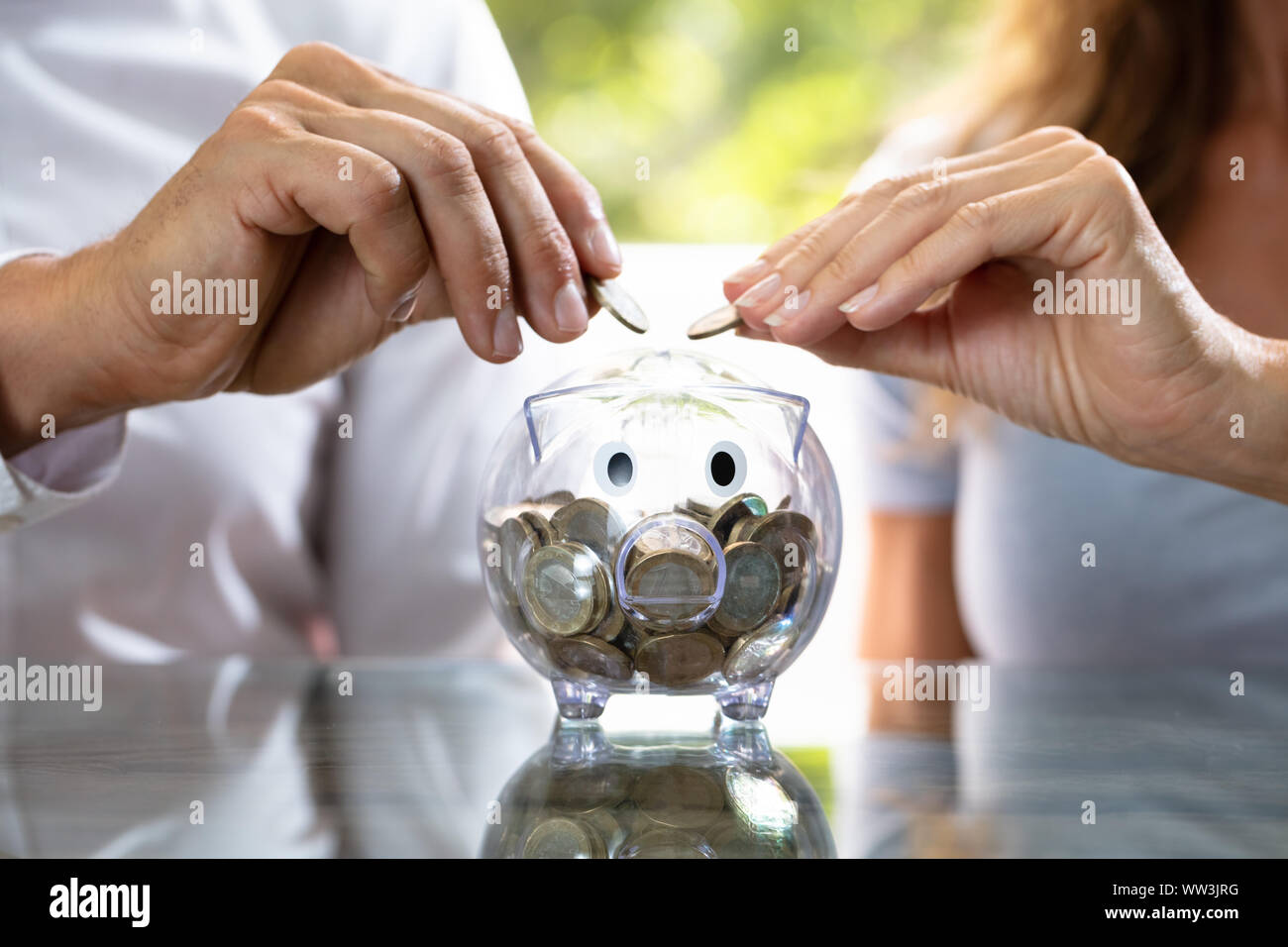 La mi-section de l'insertion de deux coins en Transparent Piggybank Banque D'Images