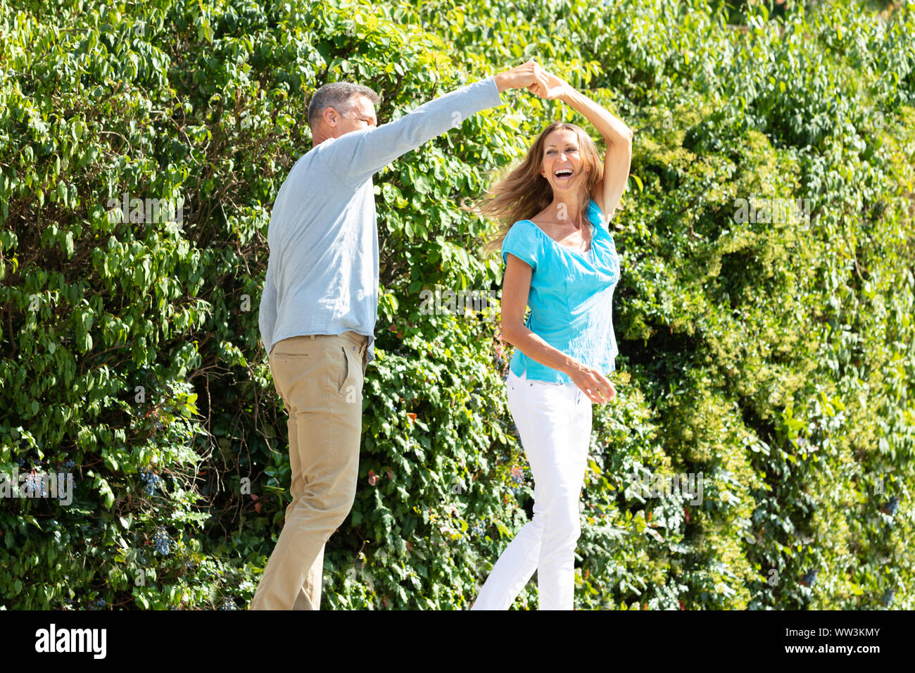 Portrait Of Happy Young Couple Dancing in Green Park Banque D'Images
