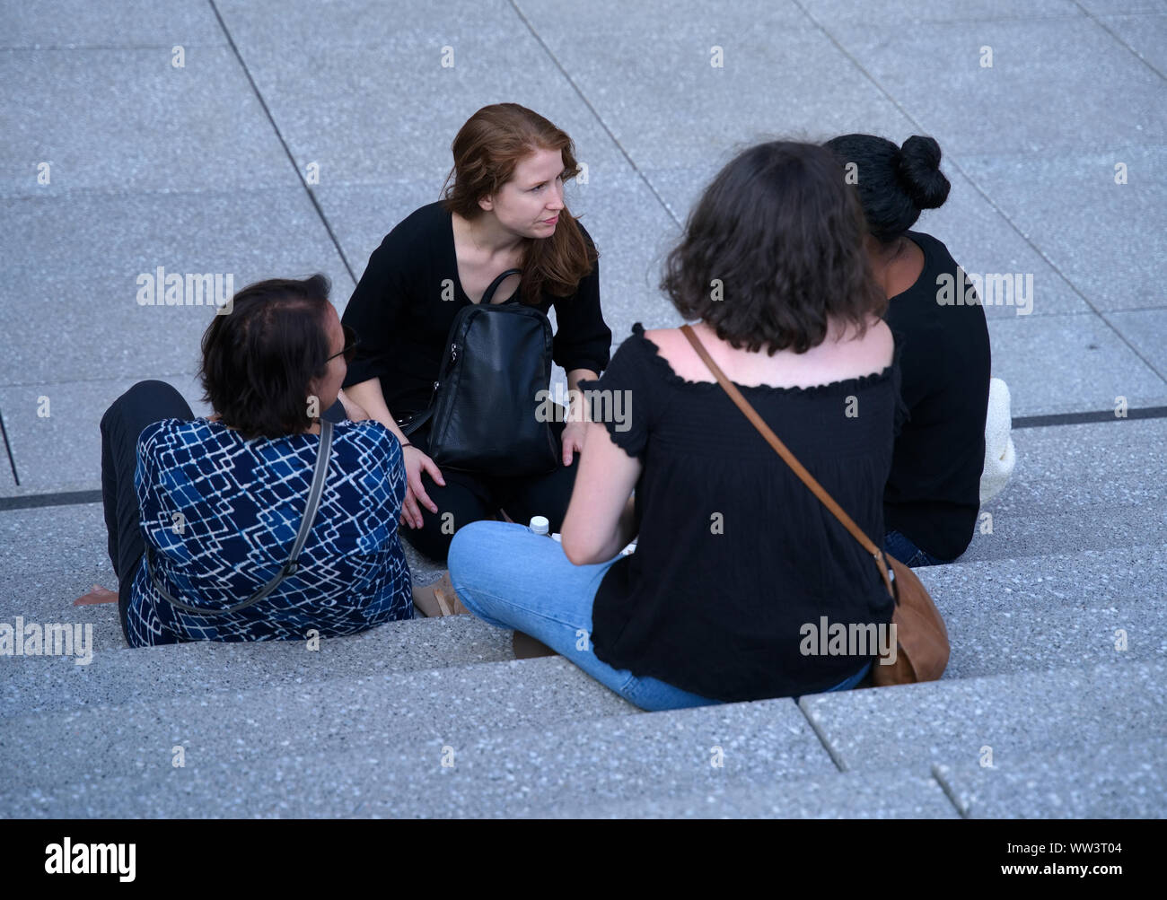 Montréal, Canada. Jul 2019. Groupe de jeunes femmes canadiennes en dehors de parler et se détendre tout en étant assis sur des escaliers. Banque D'Images