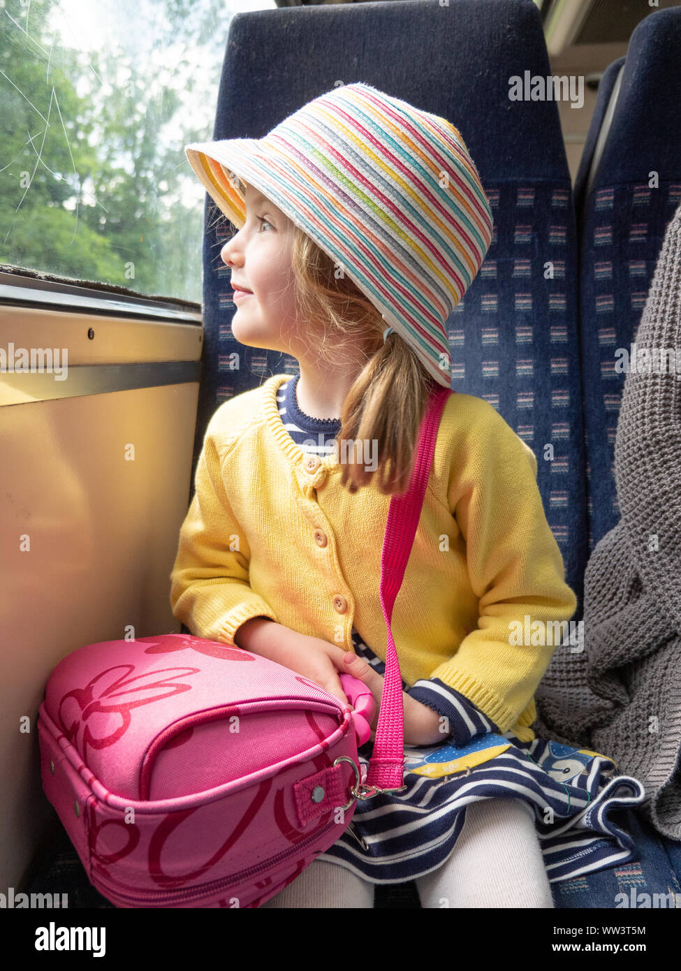 Jeune fille à la mode regardant hors de la fenêtre de train sur un voyage, Londres, Royaume-Uni Banque D'Images