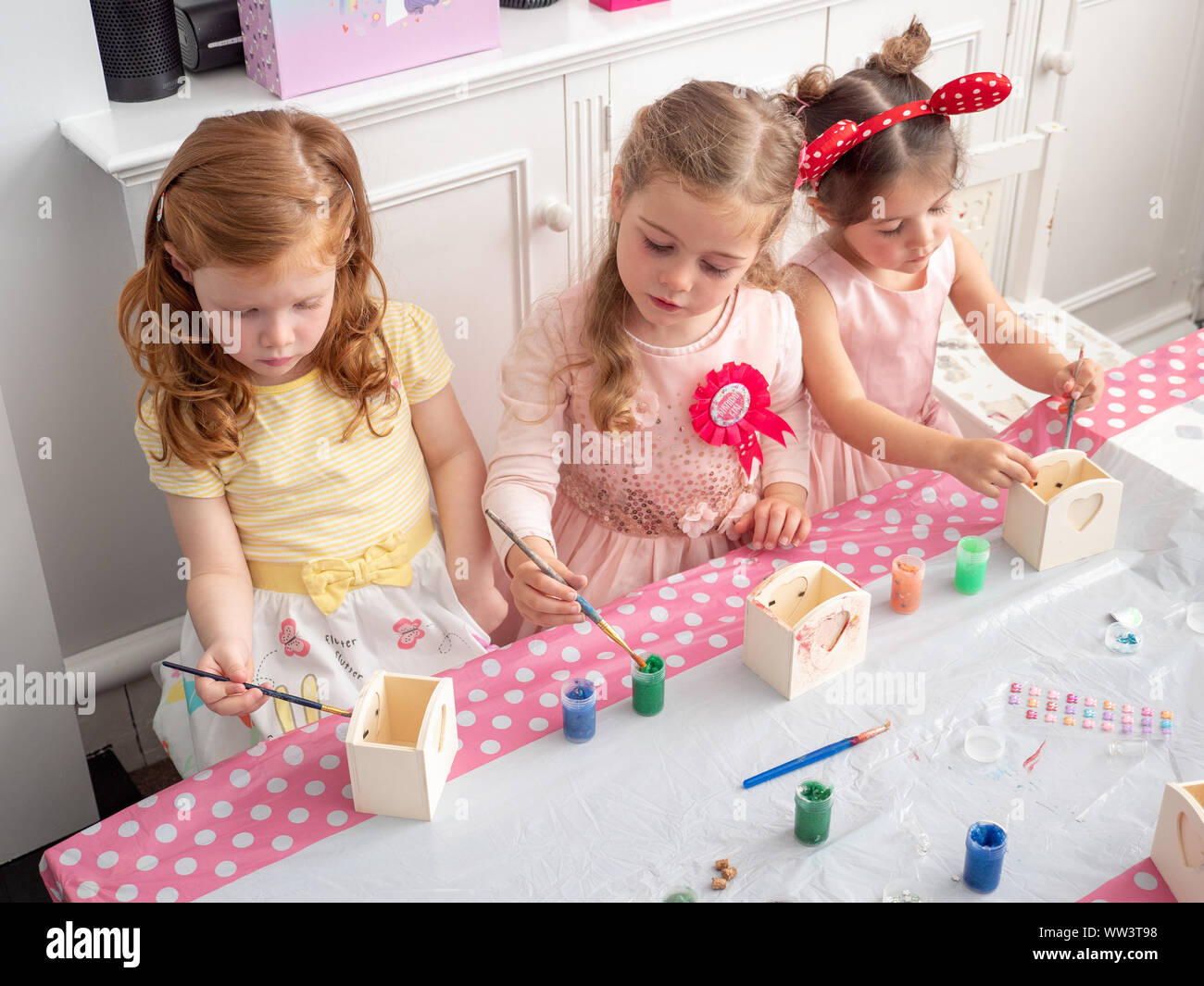 Petits jeunes filles faisant de l'artisanat à un anniversaire, UK Banque D'Images