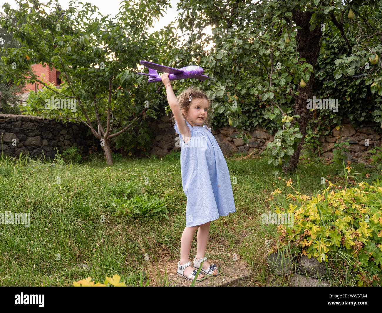 Jeune fille voler son jouet avion dans le jardin, Bulgarie Banque D'Images