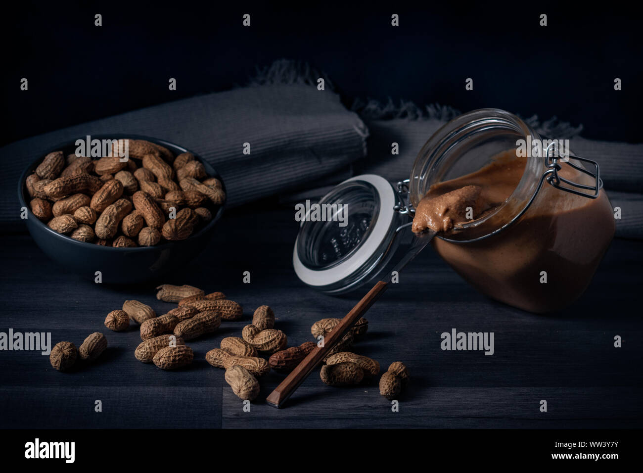 Photographie de beurre d'arachide avec quelques cacahuètes dans un bol, la photographie est prise avec un style alimentaire. Banque D'Images