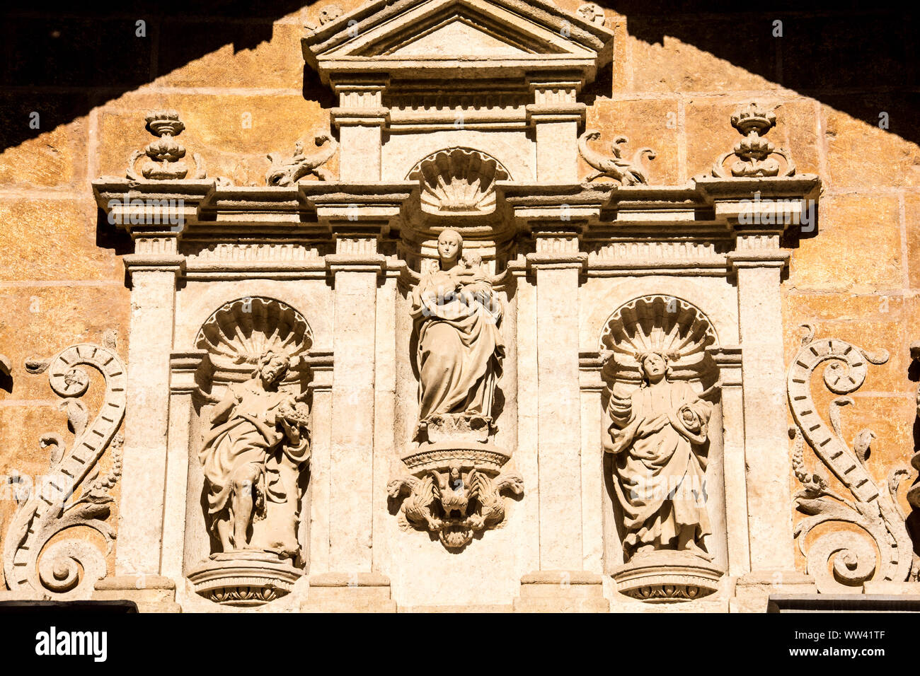 Mur extérieur de la cathédrale de Grenade, en Espagne, orné de symboles et de figures religieux. Banque D'Images
