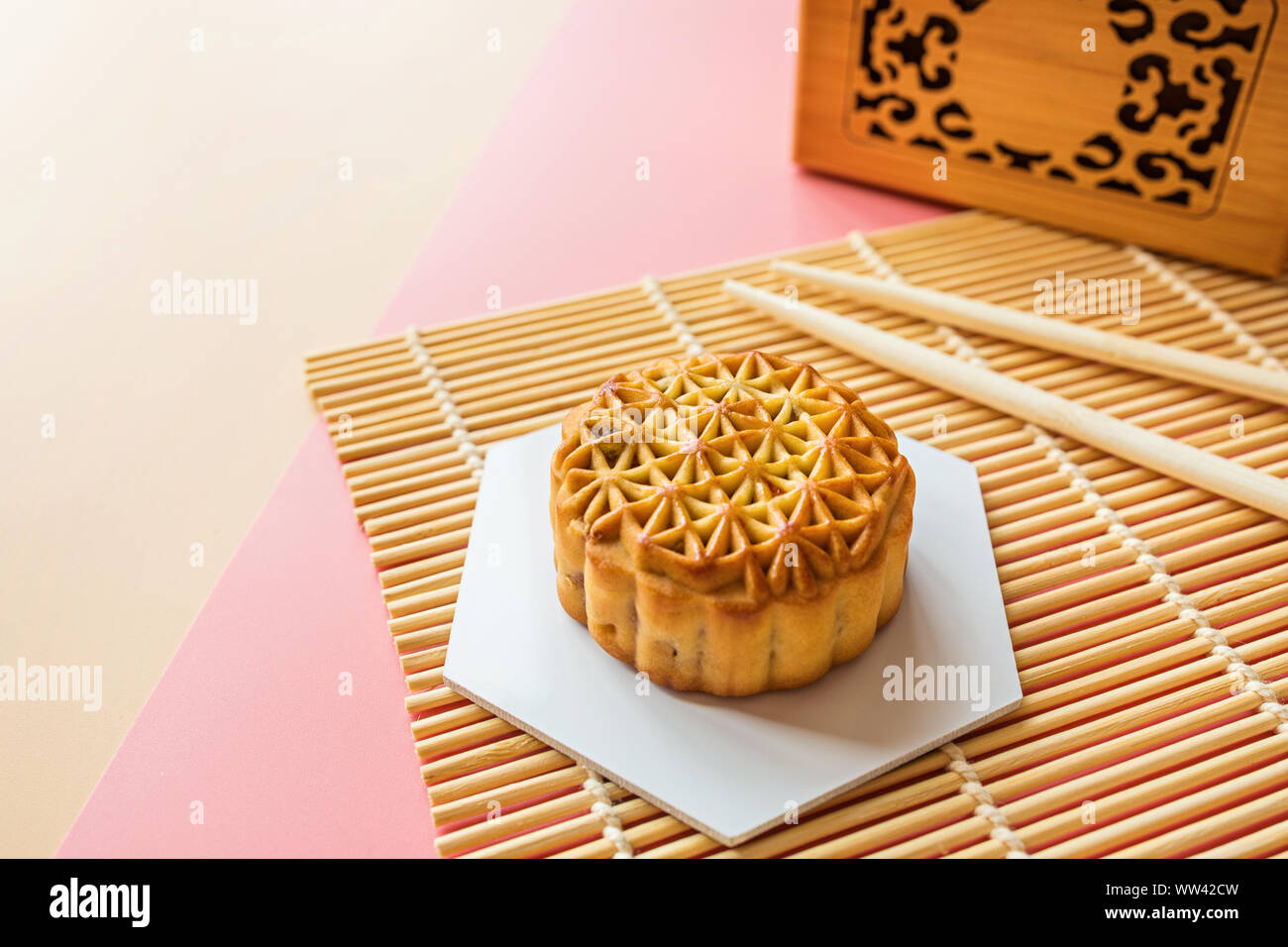 Festival traditionnel chinois, dessert gâteau de lune Festival de mi-automne sur fond coloré avec des baguettes. Vue de dessus, copiez l'espace, immersive, frais généraux Banque D'Images