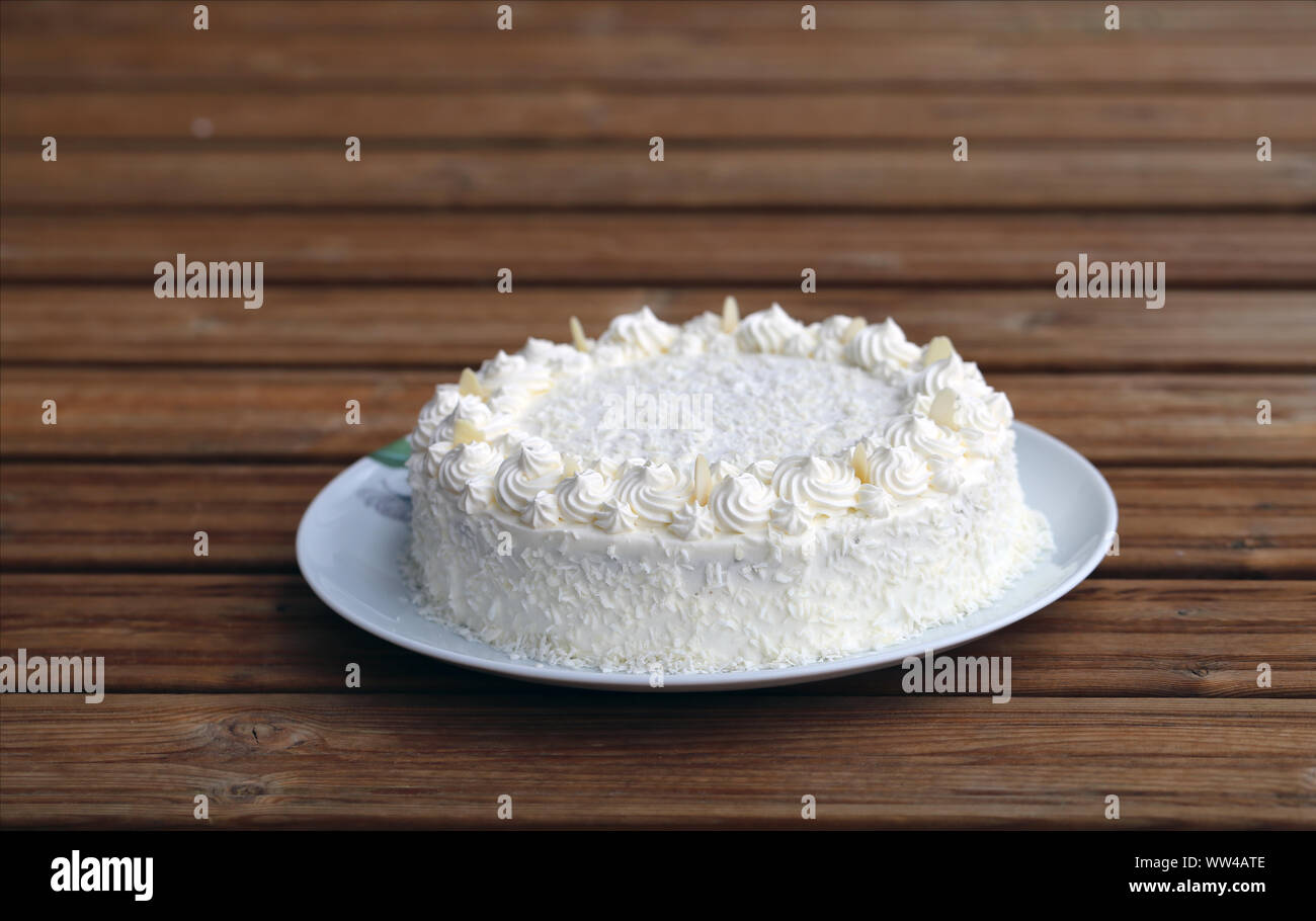 Gâteau Raffaello maison gâteau aux amandes (noix de coco) dans un gros plan. Décorée de crème fouettée, noix de coco et des tranches d'amandes. Belle, pâtisserie détaillées. Banque D'Images