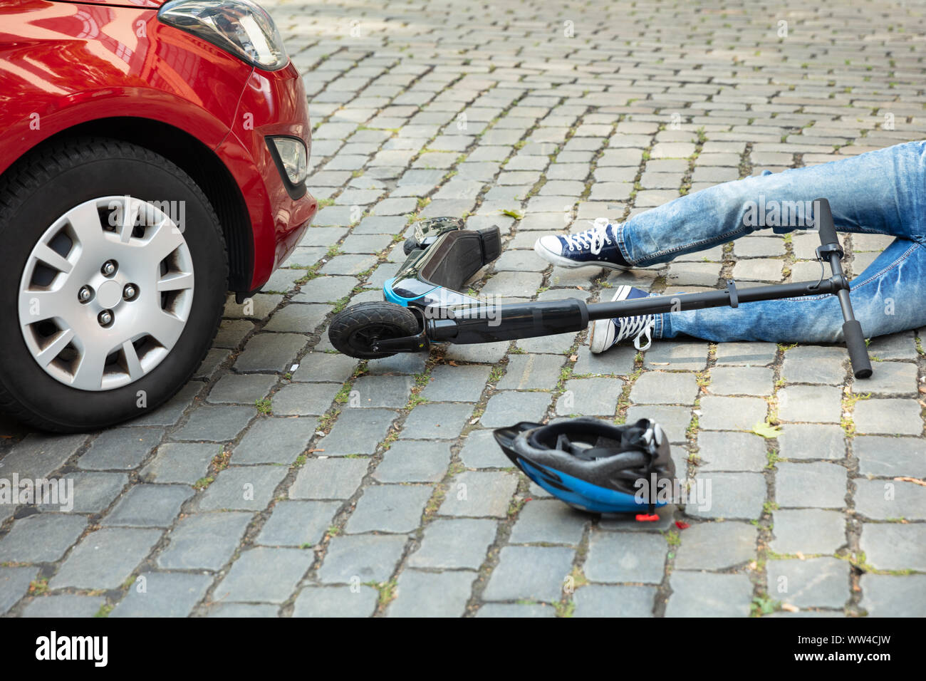 Homme après accident sur scooter électrique envahie par voiture Banque D'Images