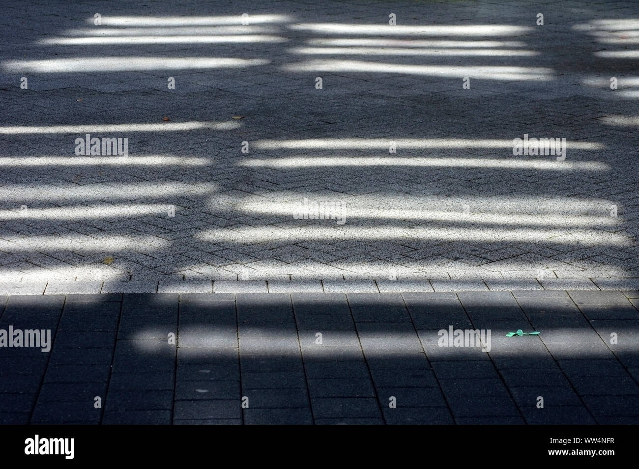 Substitution, reflets de lumière et sur les pavés d'un trottoir, Banque D'Images