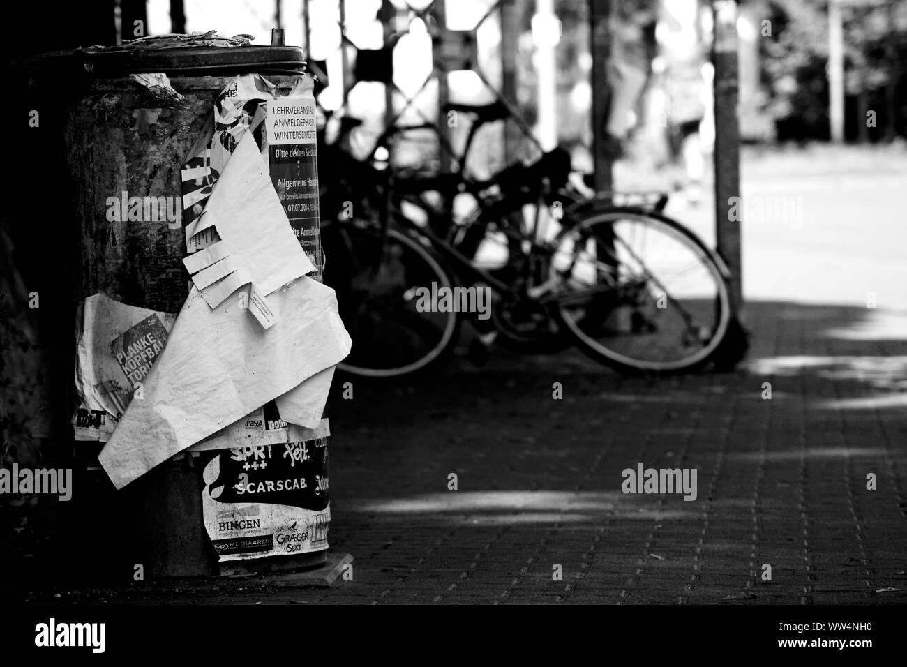 La photographie monochrome d'une poubelle en face d'un vélo, Banque D'Images