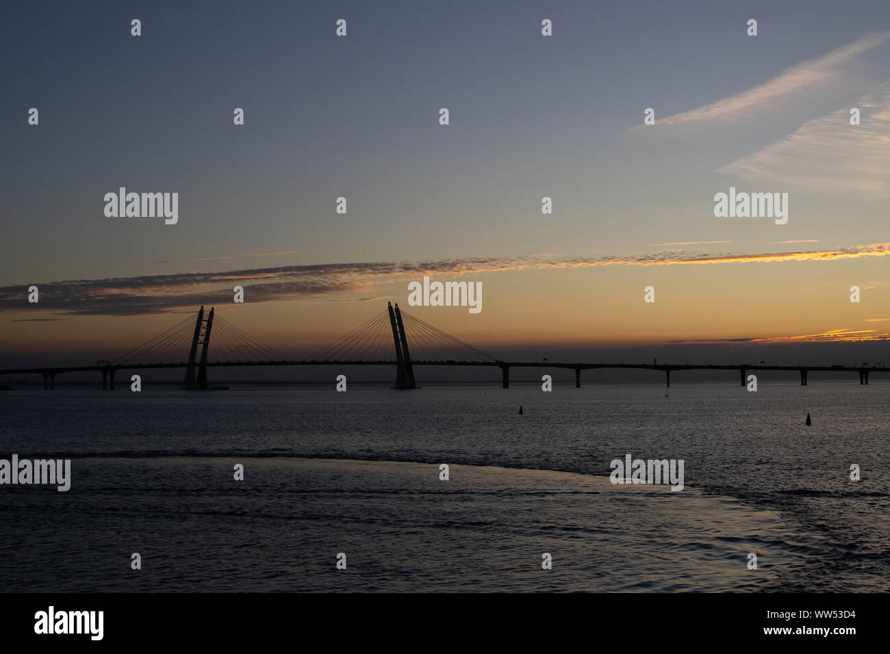 Long pont à haubans sur l'arrière-plan d'un magnifique coucher de soleil sur la mer Banque D'Images